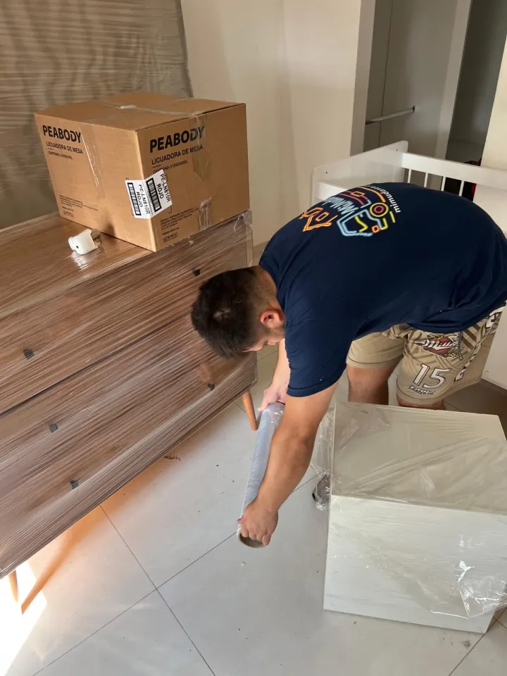 Operario de Mi Mudanza protegiendo muebles y cajas antes de la carga